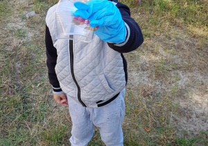 zdjęcie przedstawia przedszkolaka ze znalezionym plastikowym kubeczkiem